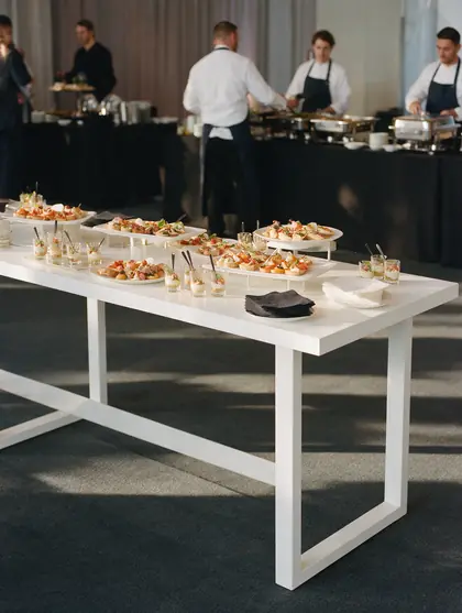 Buffet de traiteur dressé pour un événement d'entreprise, plateaux et verrines sur une longue table
